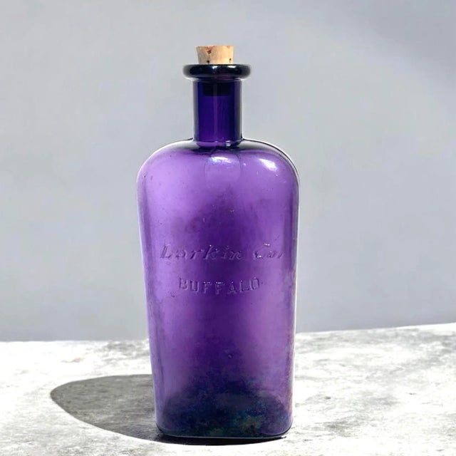 This early 20th-century amethyst glass bottle was produced by the Larkin Company of Buffalo, New York, known for its...