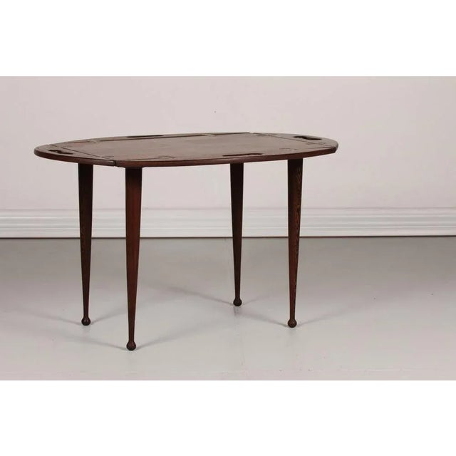 Butlers tray attributed to the Danish designer Jeanne Grut. It is made of wengé with 4 drumstick legs. The table has...
