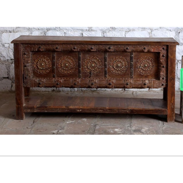 Elevate your entryway with this exquisite antique Indian console table, richly hand-carved with intricate floral motifs...