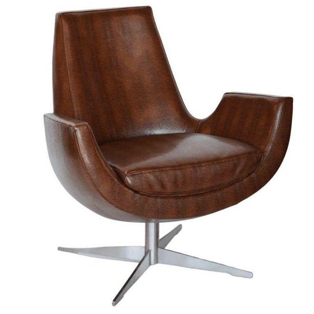 A striking pair of mid-century modern lounge chairs, newly upholstered in supple brown leather. These chairs feature a...