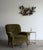 A generously scaled club chair with low sprawling proportions and deeply rolled scroll arms. The frame rests on carved...