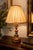 Elegant Italian vintage table lamp featuring a finely turned polychrome wooden structure with distressed gilt finishes and...