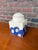 This handsome ceramic jar features a cream-white base with soft blue accents, finished in a smooth, clean glaze that gives...