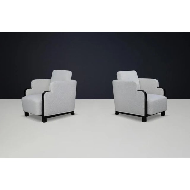 Pair of Art Deco Armchairs in Bouclé and Black Lacquered Wood, Prague, 1930s This exquisite pair of Art Deco armchairs,...