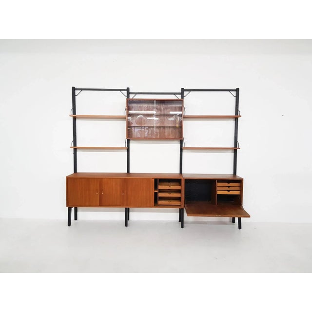 Large free standing wall unit by Poul Cadovius for Royal system. With 4 black metal risers and teak veneer cabinets and...