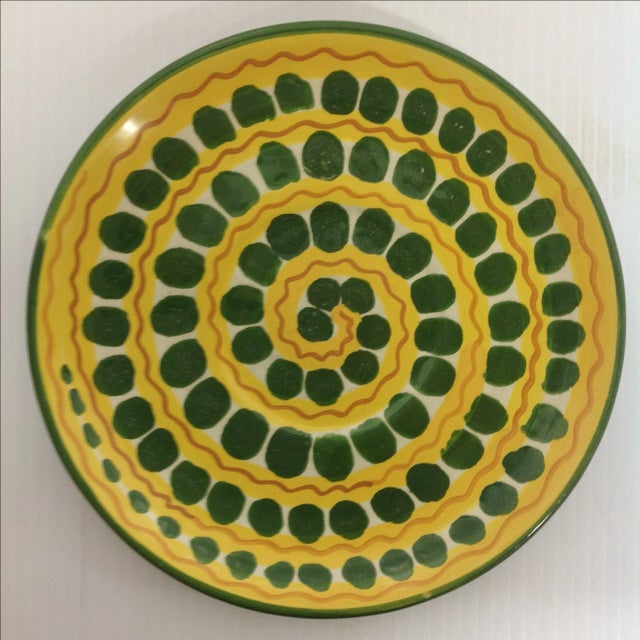 This Italian charger features a pattern of green circles spiraling across a yellow ground, with red zig zags adding a...