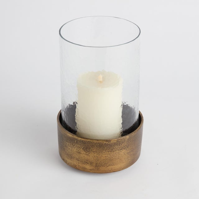 Made of hammered glass and cast aluminum, this hurricane has a classic look. The antique brass finish plays well in...