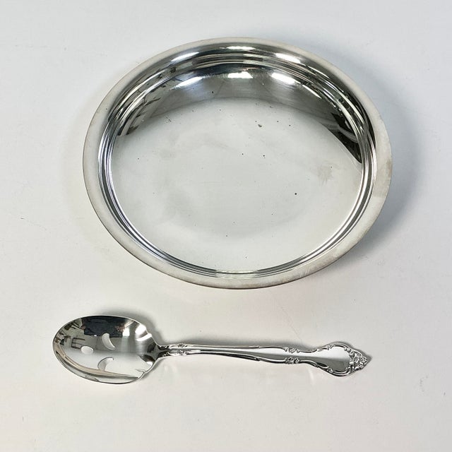 This small serving dish with slotted spoon is from Oneida and is the Community pattern. It’s from the Mid-Century and is a...