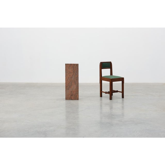 A striking rectangular pedestal crafted from polished red granite, produced in Belgium during the 20th century. Defined by...
