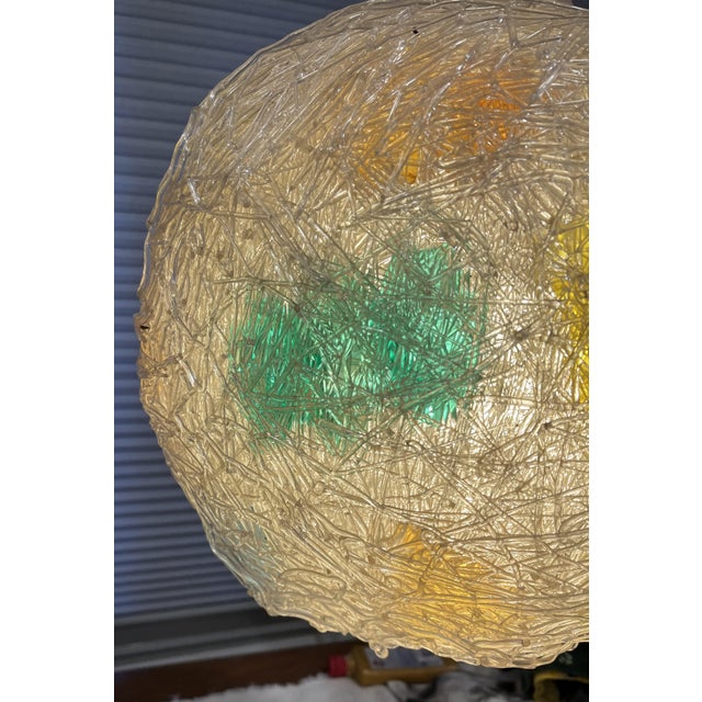 Hanging Pendant lamp made of acrylic namely Lucite. 13 inch in diameter on a brass chain. shown as illuminated with...