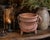 A beautifully aged antique primitive cast iron cauldron featuring three sturdy legs and an old swing bail handle, possibly...
