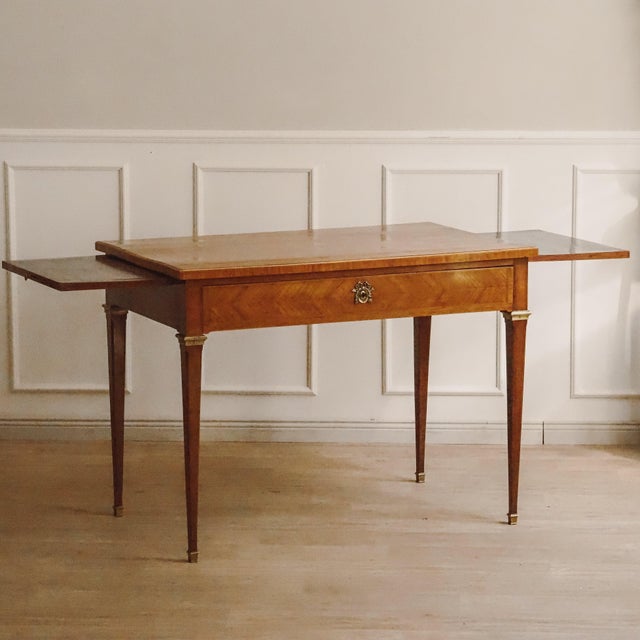 Antique Louis XVI style writing desk, France, circa 1880–1900, with a veneered body, brass fittings, and two side...