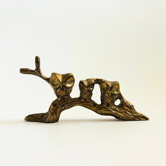 A vintage brass sculpture of 3 owls perched on a branch. Measures 6.75"W x .75"D x 3.5"H