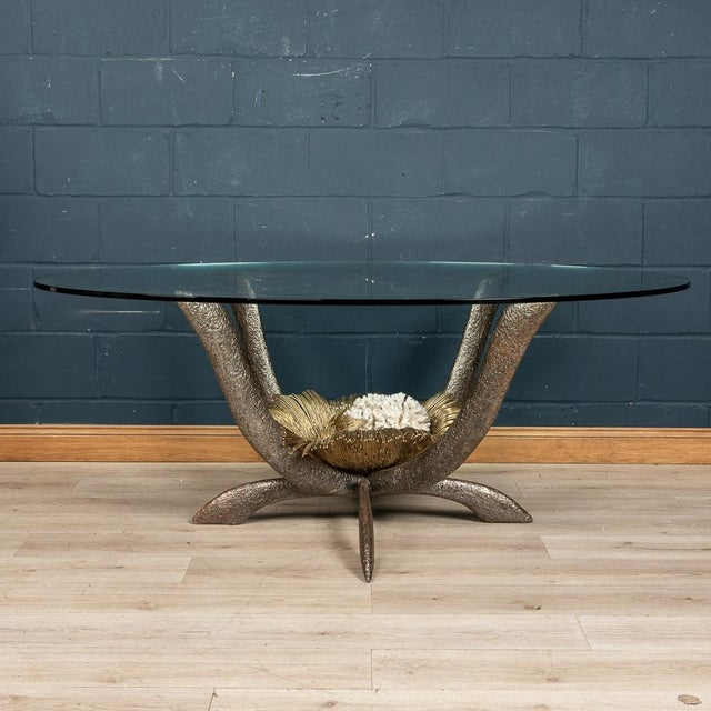 A rare and impressive dining table by Jacques Duval-Brasseur, made in France around the 1970s. The thick oval glass is...