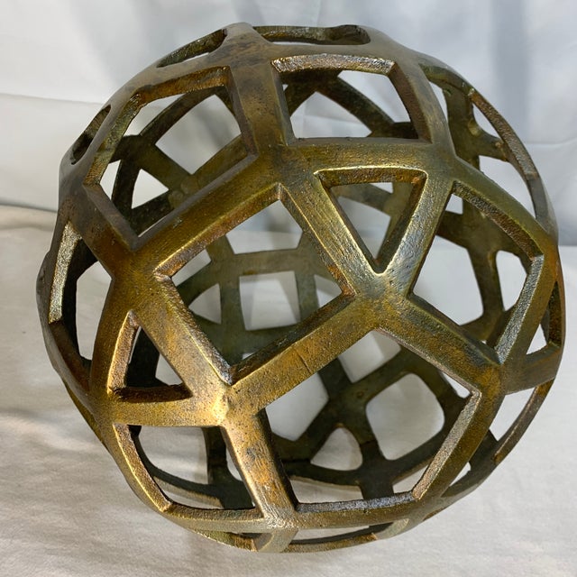 This is a textured brass geometric cutout decorative sphere with an openwork honeycomb lattice design. 11 diameter.
