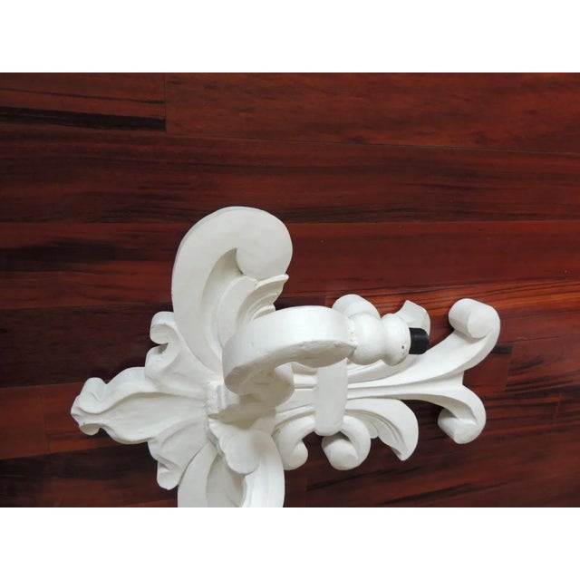 Vintage white plaster on carved wood "Flor de Lis" wall sconce. Two light electric wall light. Size: 18" H x 15" W x 8" D.