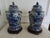 A fabulous pair of well painted temple jars with foo dog finials. Also included is a pair of well carved stands which cost...