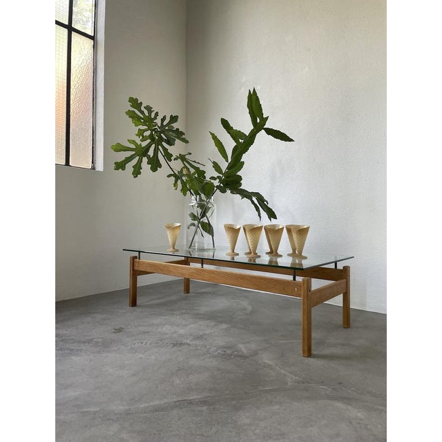 Antique Scandinavian coffee table from the 60s, with a blond teak frame and lovely brass details. The glass top rests on...