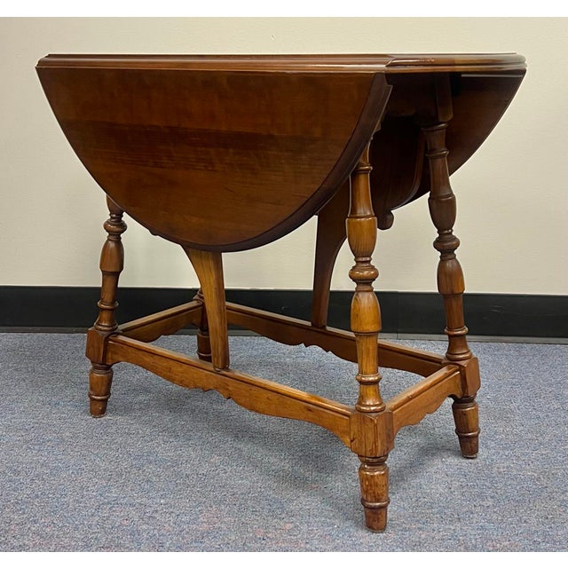 Elegant vintage splayed leg drop leaf side table with butterfly supports. Crafted in solid cherry with beautifully turned...