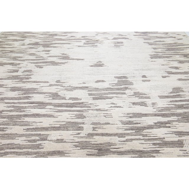 Beautiful modern Moroccan-style hand-knotted wool rug with a beige and ivory color field. This rug is part of our...