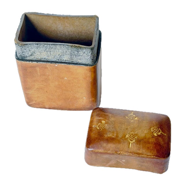 Antique Italian Florentine leather lidded matchstick box and striker with embossed gilt abstracted floral pattern on top....