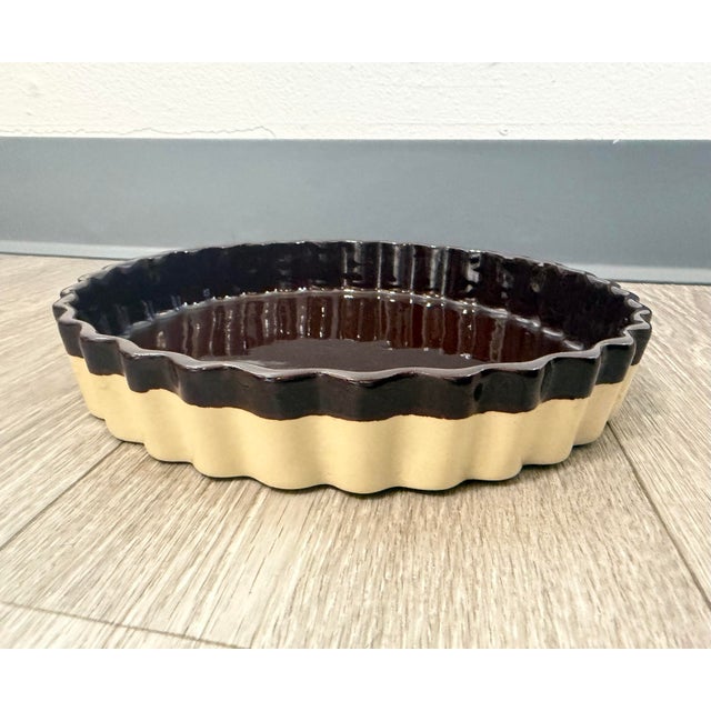 This vintage ceramic tart dish features a beautiful two‑tone design: a glossy deep‑brown interior paired with a warm,...