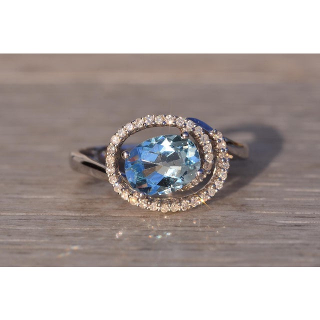 The 28th Avenue: Aquamarine and Diamond Spiral Ring in White Gold. The ring features a central oval checkerboard cut...