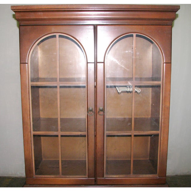 Traditional style walnut wood storage hutch from the 1950s with a simple arched design. There is a large upper cabinet...