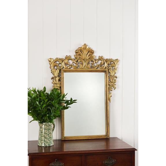 Antique French giltwood mirror with an ornately carved frame, shaped crest, and beveled glass. A classic statement piece...