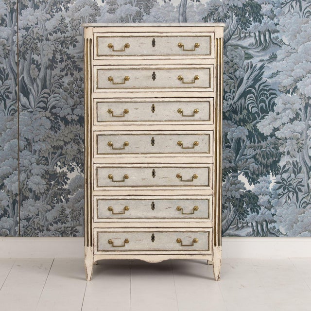 A charming French tall chest of drawers from the 18th century with fluted round corner posts. Beautiful patina with...