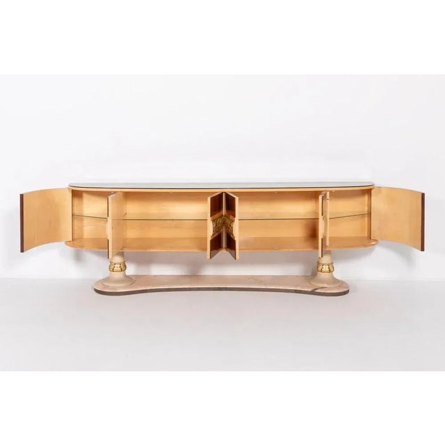 Italian Mid-Century sideboard from Arredementi Borsani, 1950’s. It features 6 doors with glass shelves behind them, tinted...