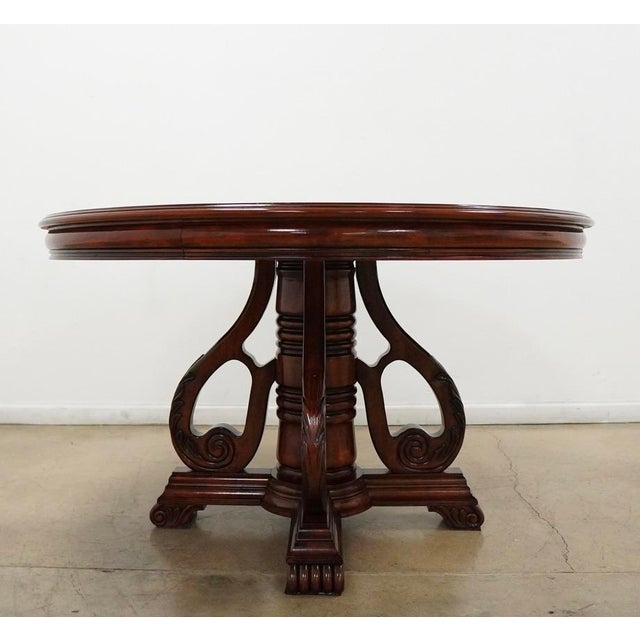 Beautiful round traditional dining table featuring a rich dark cherry mahogany-style finish, decorative veneer top with a...