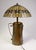 A substantial and visually commanding Arts and Crafts table lamp, comprising an antique copper and brass vase base...