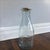 Star milk bottle with cork. Has an image of a cow on one side and "milk, 1890" and a star. Perfect condition. 18"in height.