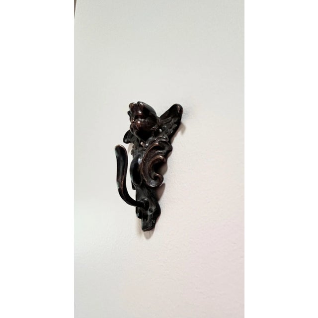 This lovely detailed hook is made in the form of a cherub and is made of dark metal with rubbed copper highlights....