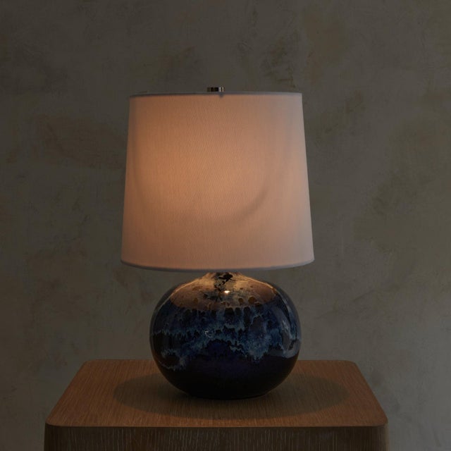 A petite 1960s French studio pottery lamp with a luminous glaze in inky blue and chalky white. The rounded ceramic base is...