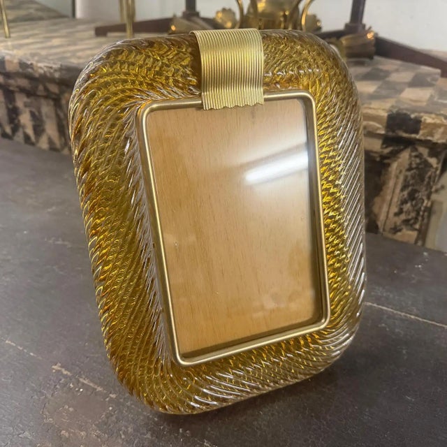 An amber Murano glass rectangular picture frame designed and manufactured in Venice in the style of Barovier. The vintage...