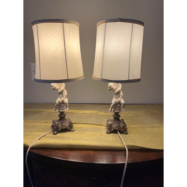 Add classic Hollywood Regency elegance to your space with this gorgeous, matching pair of vintage mid-century cherub table...
