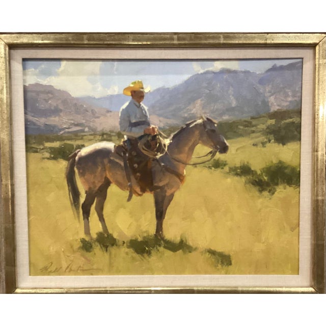 The painting depicts a cowboy in a straw hat riding a gray horse through a mountainous desert landscape. Anton's work has...