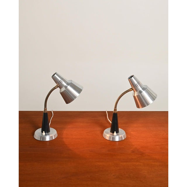 Adjustable aluminum diffusers, flexible brass neck, black-painted metal conical support, and satin-finish aluminum bases....
