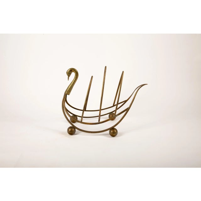 A charming mid-century patinated brass magazine or newspaper rack designed in the elegant form of a swan. The graceful...