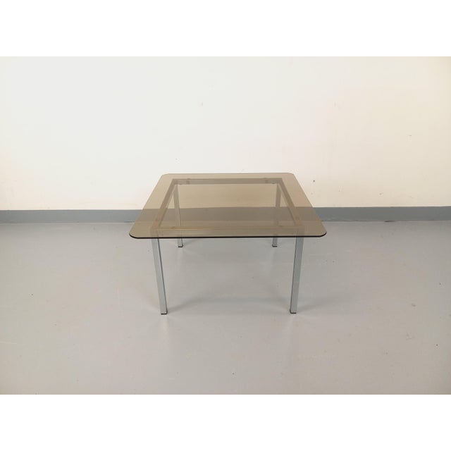 Vintage square coffee table from the 1970s, in the style of Florence Knoll or Milo Baughman, with a square smoked glass...