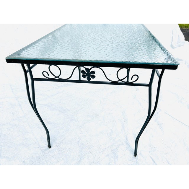 70's Midcentury Black Wrought Iron Outdoor Texture Glass Top Table In very good condition. 48"L X 30"D X 29.5"H Knee H 25"