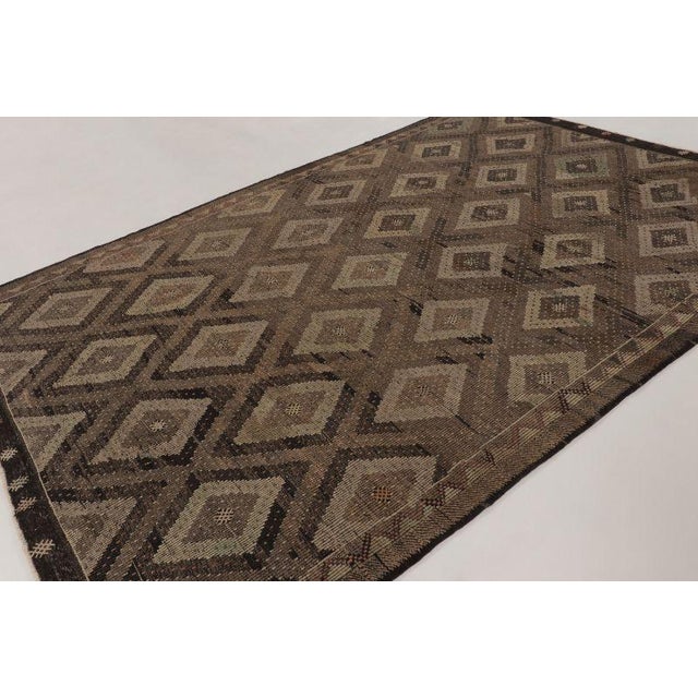 This vintage 8x12 Turkish kilim is a sophisticated handwoven wool flatweave dating to circa 1950–1960. The piece features...