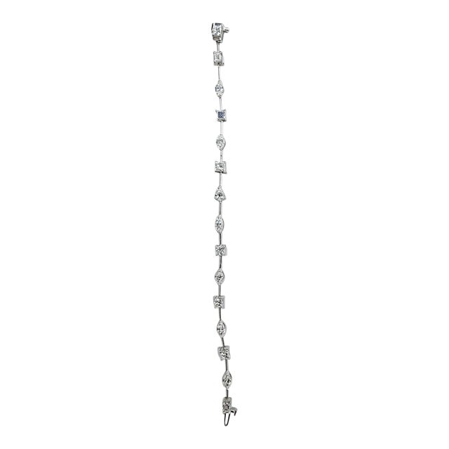 An elegant 18K white gold diamond bracelet featuring 6.70 carats total weight of natural multi-shape diamonds. Showcasing...