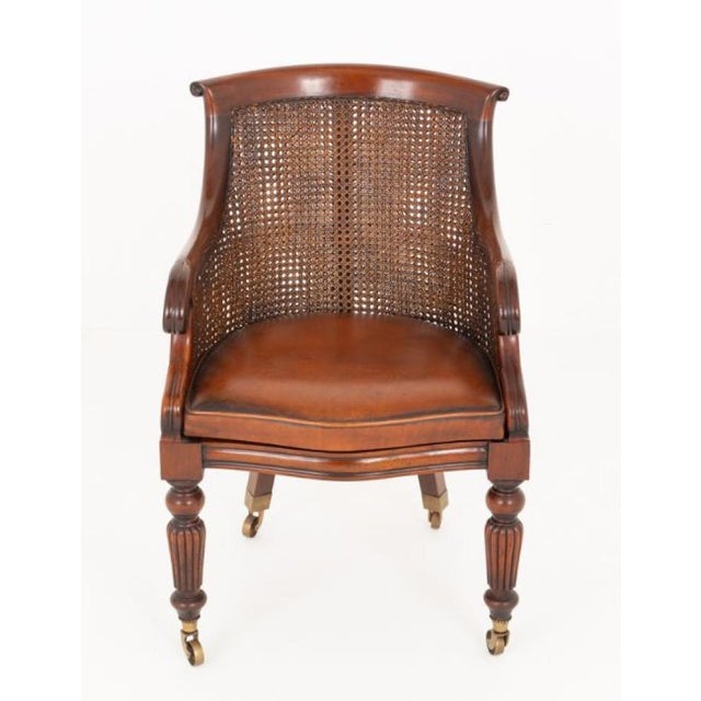 This impressive Regency Revival desk chair is crafted from fine mahogany and stands on ring-turned and fluted front legs,...