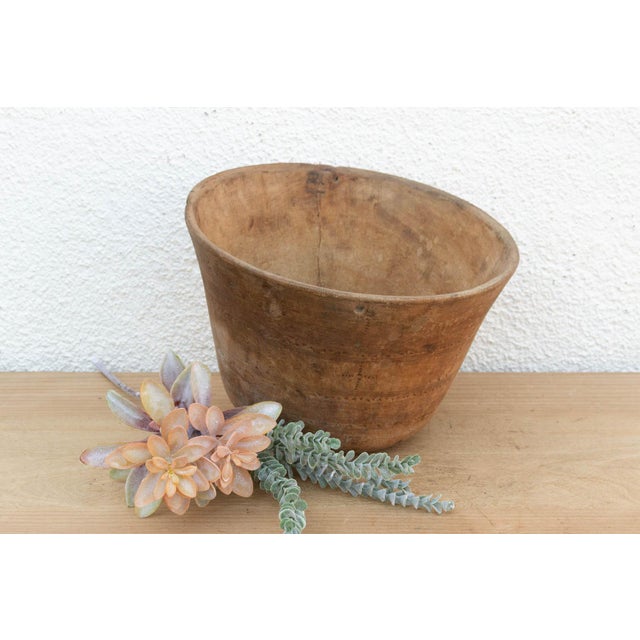 There’s something deeply grounding about holding a vessel carved by hand from a single block of wood. This antique African...