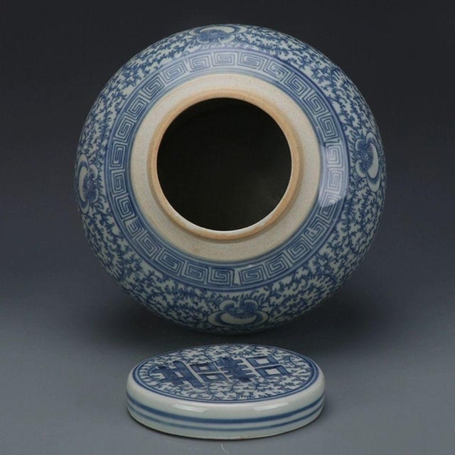 Classic Chinese blue‑and‑white lidded jar decorated with the traditional double‑happiness (囍) character amid dense...