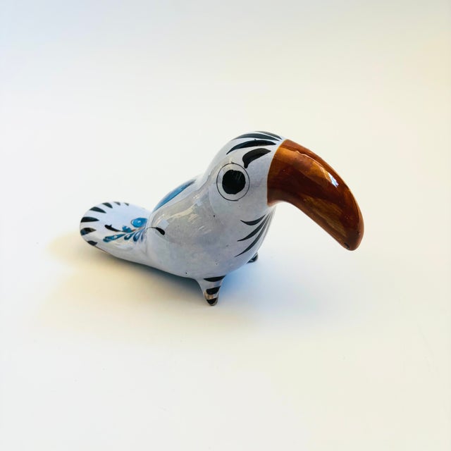 A handmade vintage Mexican folk art pottery toucan. Blue glaze with beautiful hand painted foral designs. Marked "Mexico"...