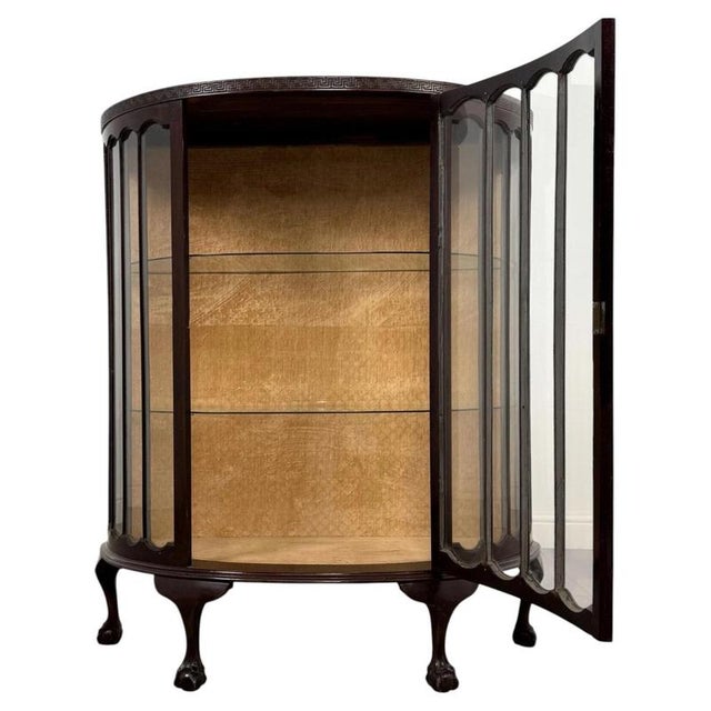 A beautifully crafted early 20th-century english edwardian display cabinet, distinguished by its elegant demi-lune form,...
